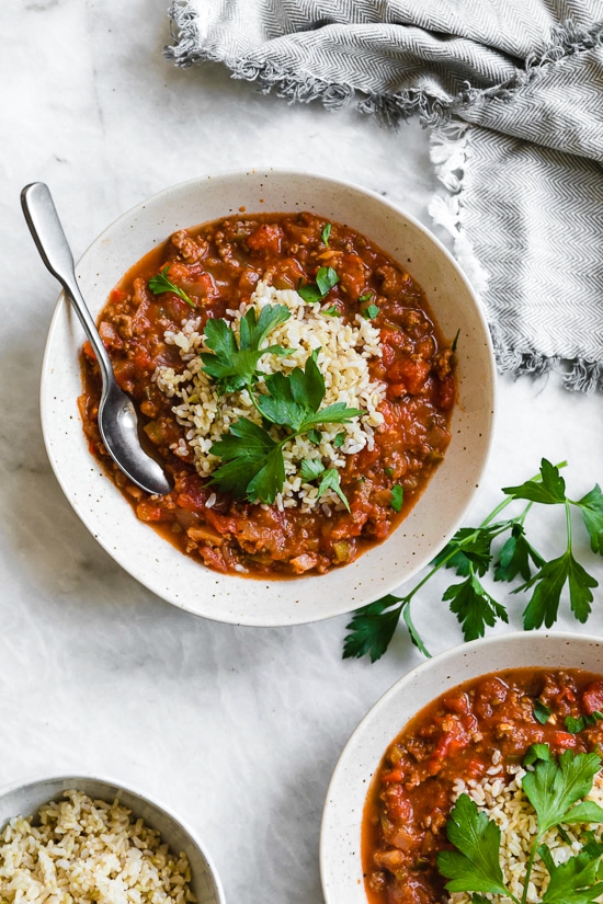 This easy stuffed pepper soup has bell peppers, ground beef, tomatoes, and rice in a hearty bowl of soup. Stovetop and Instant Pot options! Bowl of stuffed pepper soup with spoon
