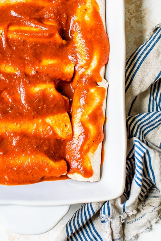 Easy vegetarian enchiladas made with butternut squash and black beans, smothered with enchilada sauce and cheese, then baked in the oven. A delicious recipe that's perfect for meatless Mondays!