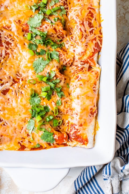 Easy vegetarian enchiladas made with butternut squash and black beans, smothered with enchilada sauce and cheese, then baked in the oven. A delicious recipe that's perfect for meatless Mondays!