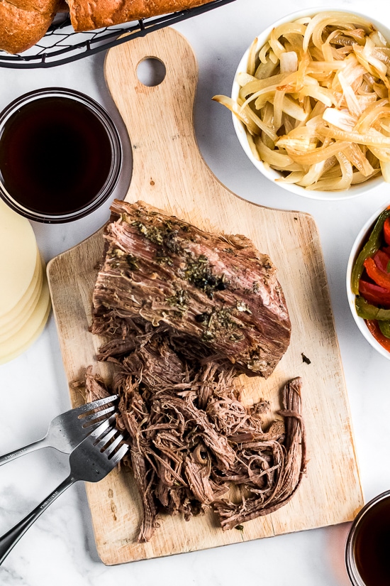 Slow Cooker French Dip Sandwich with Caramelized Onions filled with beef, melted cheese and au jus (beef broth) for dipping–the perfect weekend crock pot recipe!