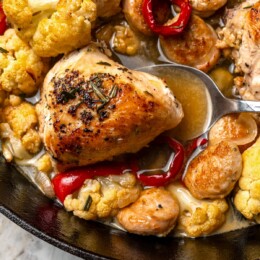 Spoon scooping chicken scarpariello from pan.