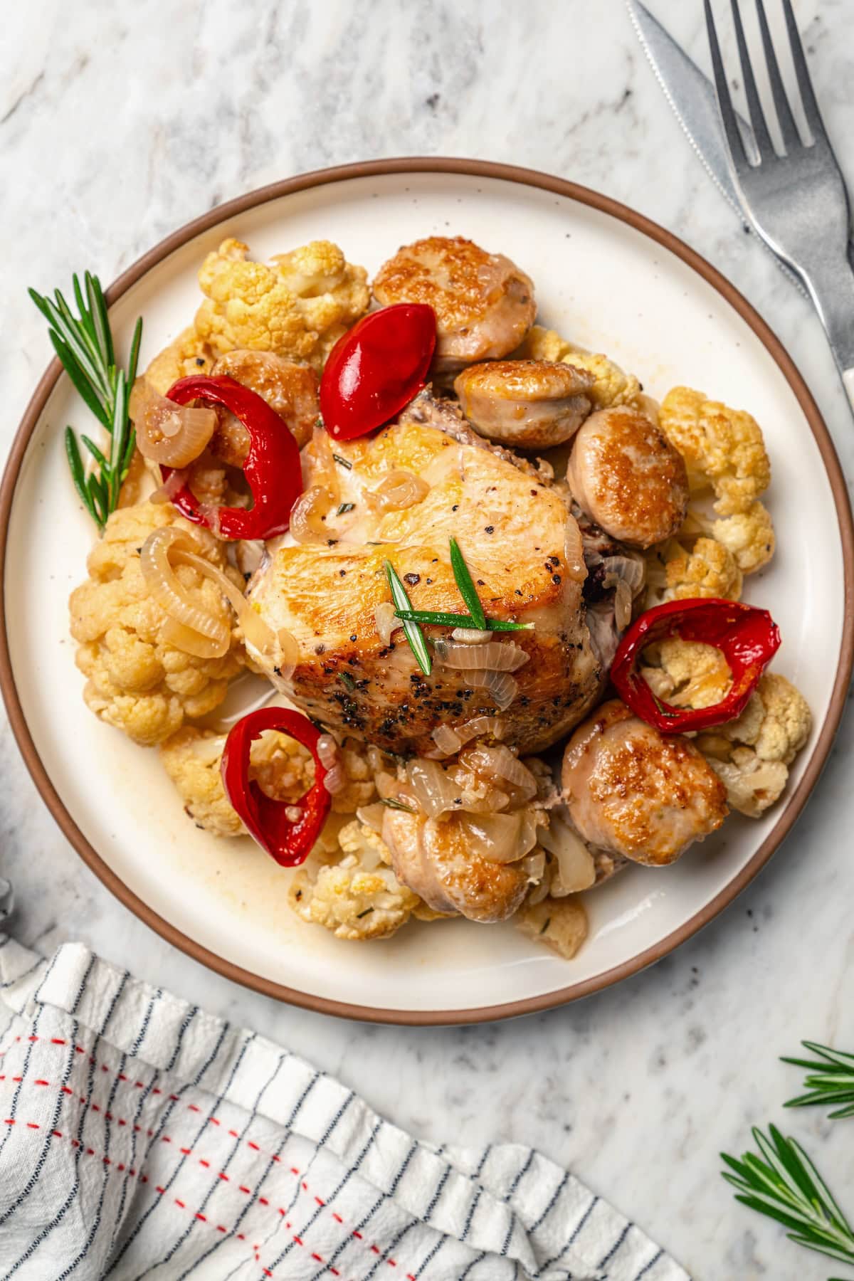 Cauliflower and chicken breasts make this Chicken Scarpariello recipe low carb, but it's just as spicy and flavorful as the classic version! Plate of chicken scarpariello with sausage, peppers, and cauliflower.