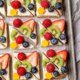 Overhead view of sugar cookie fruit pizza on sheet pan