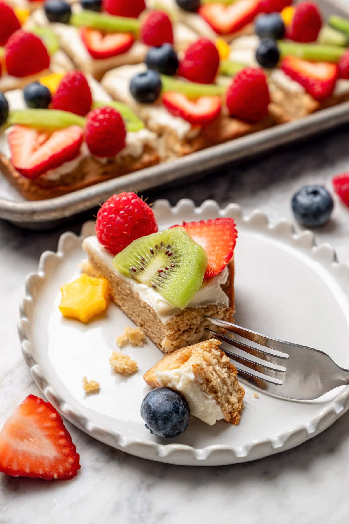 Fruit pizza on plate with tip cut off with fork
