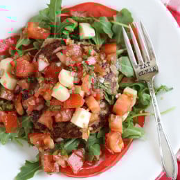 Naked Turkey Bruschetta Burger are healthy, delicious, turkey burgers made juicy thanks to added zucchini and topped with a summer garden tomato bruschetta topping over a bed of baby arugula – no bun required!