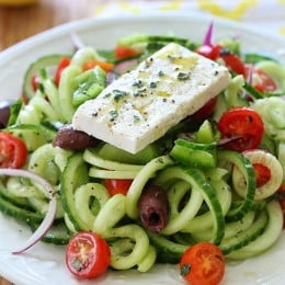 Spiralized Greek Cucumber Salad with Lemon and Feta is delicious, the perfect light dish. In Greece, Greek salads do not have lettuce, instead they are made with fresh cucumber, tomatoes, bell pepper, olives, red onion, oregano, lemon juice, olive oil, and fresh feta – delicious!