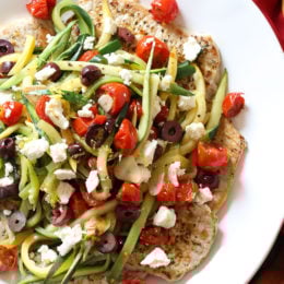 Mediterranean Boneless Pork Chops with Julienned Vegetables, a delicious, weeknight meal! Made with pan seared thin sliced boneless pork chops and served topped with sauteed julienned summer squash, roasted tomatoes, lemon juice, olives and Feta cheese. So much flavor and color in this dish!