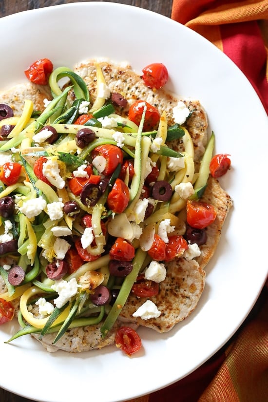 Mediterranean Boneless Pork Chops with Julienned Vegetables, a delicious, weeknight meal! Made with pan seared thin sliced boneless pork chops and served topped with sauteed julienned summer squash, roasted tomatoes, lemon juice, olives and Feta cheese. So much flavor and color in this dish!