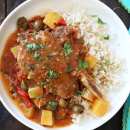 These slow cooker pork chops are seasoned with Latin spices in a flavorful sauce with tomatoes, olives, peppers and potatoes. They literally fall of the bone when they come out of the slow cooker!