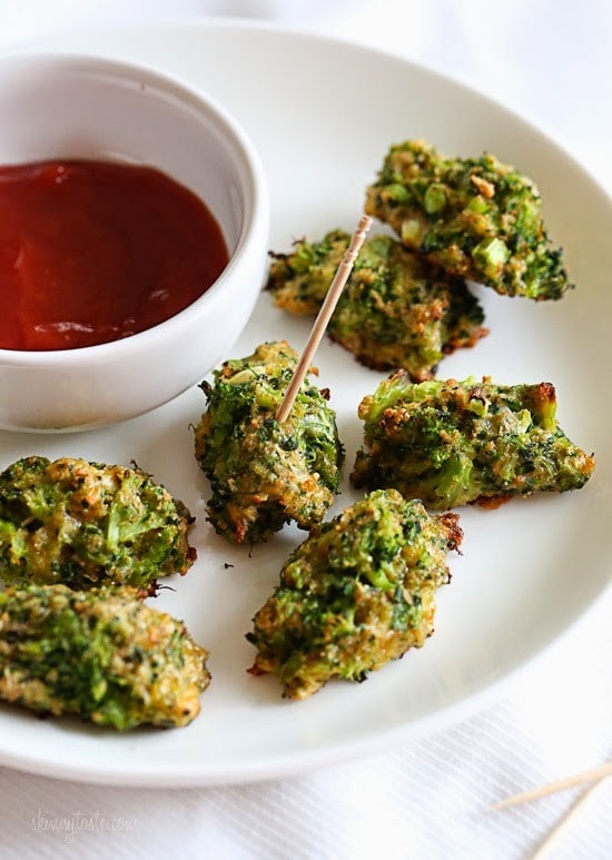 A plate of broccoli tots with a bowl of ketchup dipping sauce