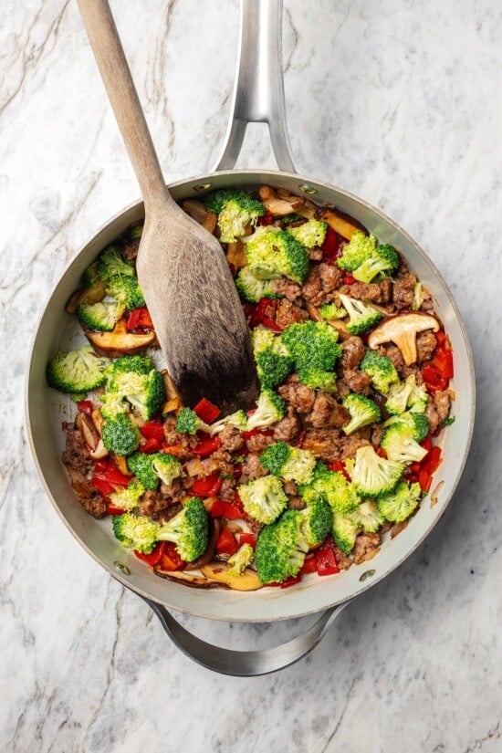 This healthy breakfast casserole recipe with sausage, cheese and veggies is hearty, flavorful, and perfect for meal prep or a weekend brunch! Skillet of vegetables and sausage.