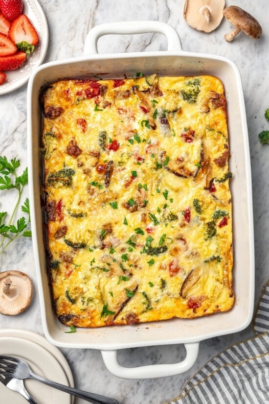 This healthy breakfast casserole recipe with sausage, cheese and veggies is hearty, flavorful, and perfect for meal prep or a weekend brunch! Breakfast casserole with sausage, cheese, and veggies in baking dish.