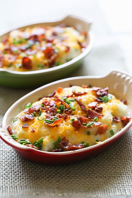 Cheesy Loaded Mashed Cauliflower makes a delicious low-carb, keto friendly alternative to mashed potatoes! Cheesy mashed cauliflower made with a touch of whipped butter, buttermilk, garlic and herbs and topped with cheese and bacon – low-carb, low calorie and keto, but you'll swear it's totally indulgent! #keto #lowcarb #weightwatchers #glutenfree #mashedcauliflower