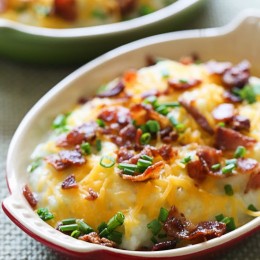 Creamy mashed cauliflower with cheese and bacon made with a touch of whipped butter, buttermilk, garlic and herbs and topped with cheese and bacon – low-carb, but you'll swear it's loaded with tons of calories!