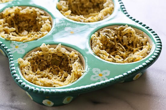A muffin pan with spaghetti squash in each tin