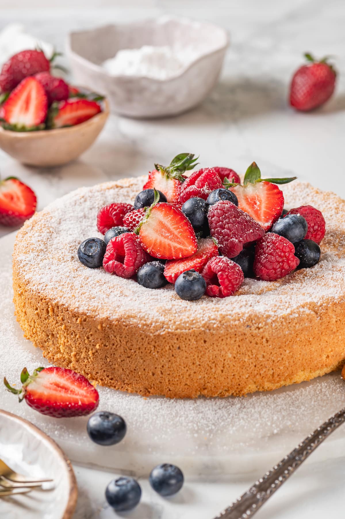 This easy almond cake recipe is made with just 5 ingredients but don't let its simplicity fool you—it's light, airy, and so delicious! Almond cake with fresh berries and powdered sugar
