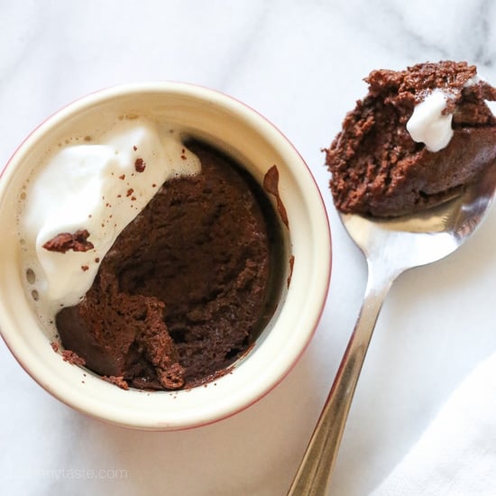 Made with 6 ingredients, this Flourless Chocolate Cake is a rich dessert guaranteed to satisfy any chocolate craving. Ready in 20 minutes! A ramekin of flourless chocolate cake next to a spoonful of cake