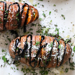 These sweet potatoes are sliced and roasted in the oven, then drizzled with balsamic and topped with parmesan and fresh herbs.