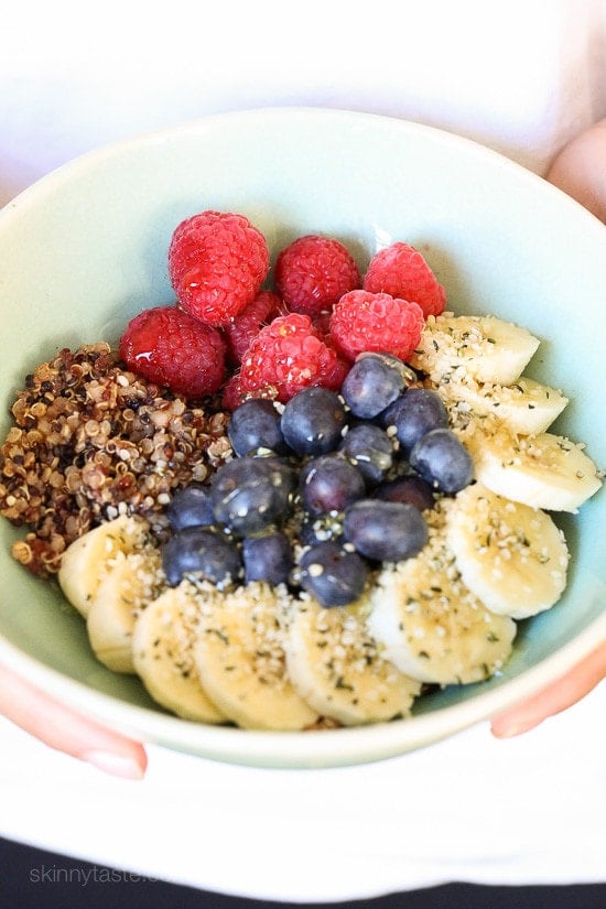 Berry Quinoa Breakfast Bowls A bowl with quinoa, sliced bananas, fresh blueberries, fresh raspberries sprinkled with hemp seeds