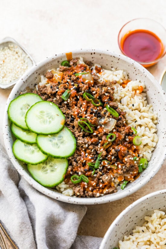 An easy and delicious Korean beef recipe is made with ground beef, served over rice with cucumbers and gochujang sauce. Assemble the rice bowls