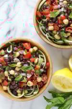 This Mediterranean Bean Salad is so light and fresh, made with lemon juice, mint and parsley. This can be served as a side dish, perfect for potlucks or to make it a main for lunch serve it over spiralized cucumbers.