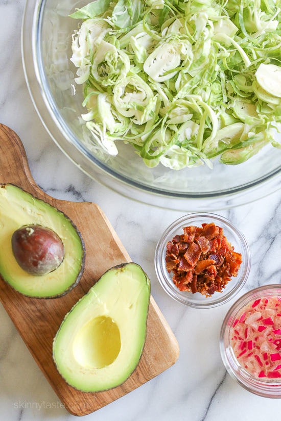 This shredded raw brussels sprout salad with bacon and avocado can be eaten as a main or a side dish. Because raw brussels stand up so well to dressing, it's also great to make ahead – just add the avocado right before serving.