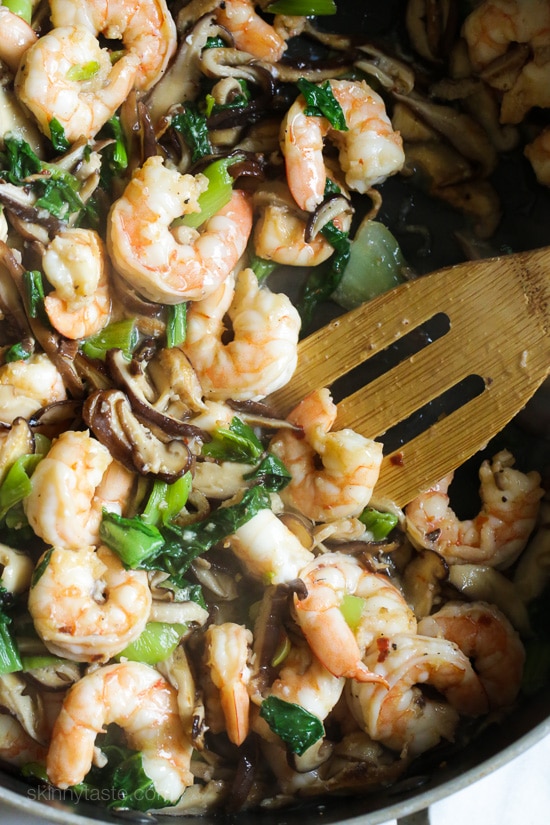 garlicky shrimp stir-fry with shiitakes and bok choy cooked in a pan.