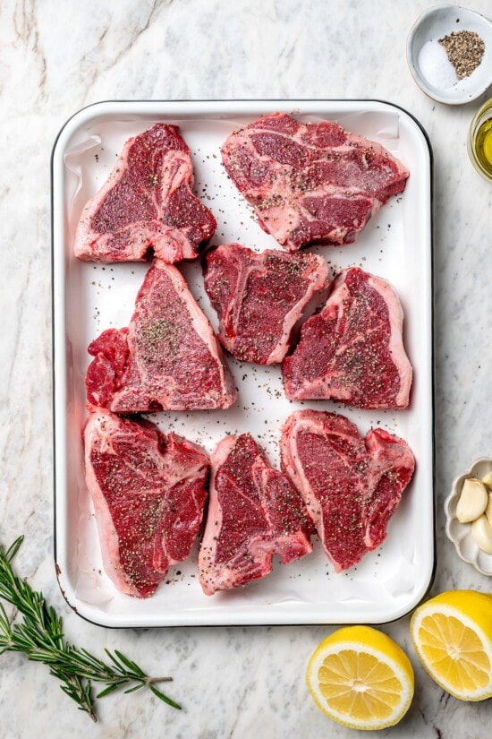 With fragrant rosemary and garlic, this easy grilled lamb chops recipe is flavorful, succulent, and one I love to cook all year long! Overhead view of seasoned lamb chops in pan