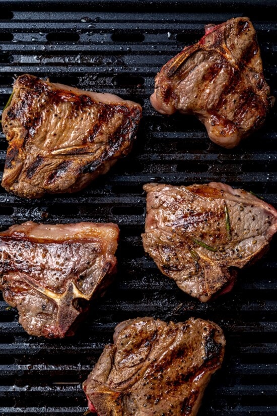 With fragrant rosemary and garlic, this easy grilled lamb chops recipe is flavorful, succulent, and one I love to cook all year long! Overhead view of grilled lamb chops on grill pan