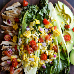 An EASY 15-minute dish you'll want to make all summer long! Fresh heads of romaine lettuce are split down the middle, grilled until slightly charred and smoky, along with fresh corn and skinless chicken thighs, then topped with tomatoes, onions, avocado and a simple salsa vinaigrette.