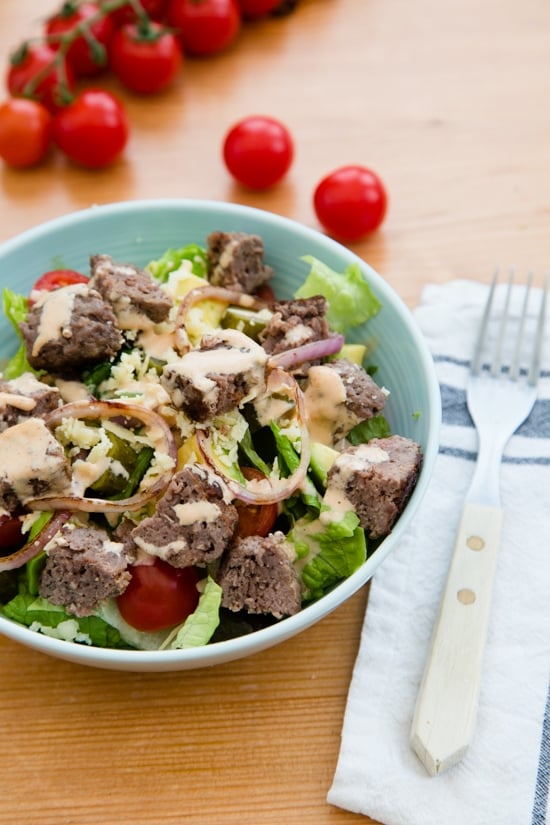 This salad has everything I love about a cheeseburger, sans the bun. Chopped romaine, tomatoes, avocado, pickles, shredded cheese topped with grilled burgers, red onions and drizzled with a seriously delicious dressing.