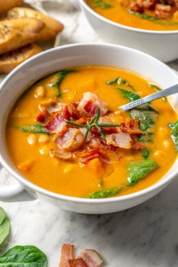 Navy bean soup in bowl with bacon on top