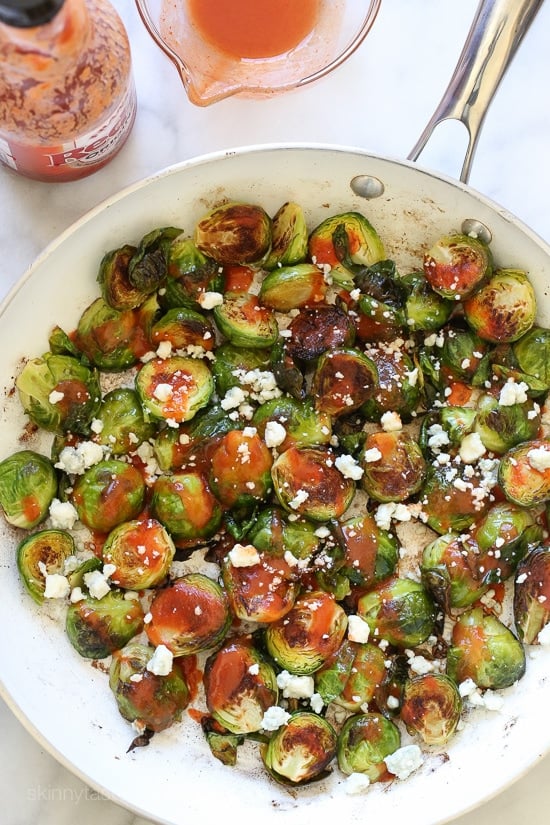 These Brussels sprouts start in the skillet and finish in the oven for perfectly charred edges, then drizzled with buffalo hot sauce and crumbled blue cheese – SO good!!