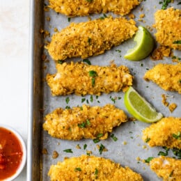 Tortilla Encrusted Chicken Tenders with lime wedges