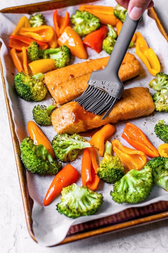 brushing teriyaki glaze on salmon