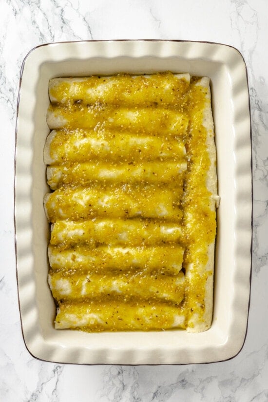 These Chicken Enchiladas Verdes (aka Green Enchiladas) are made with white corn tortillas, salsa verde, chicken breast, and queso fresco. Salsa verde poured over enchiladas