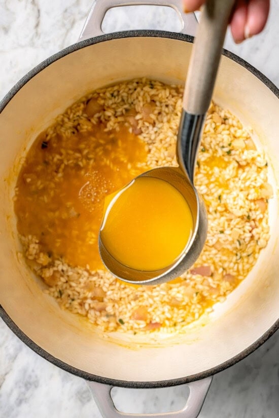 Butternut squash risotto is creamy, delicious and satisfying! It takes a little time, but it’s still easy to make—and absolutely worth it! Ladling broth mixture into risotto