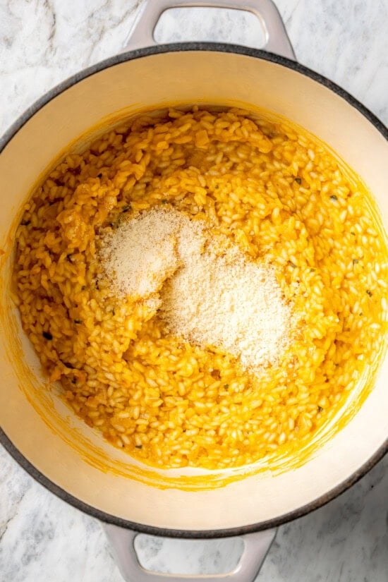 Butternut squash risotto is creamy, delicious and satisfying! It takes a little time, but it’s still easy to make—and absolutely worth it! Grated Parmesan added to pot of butternut squash risotto