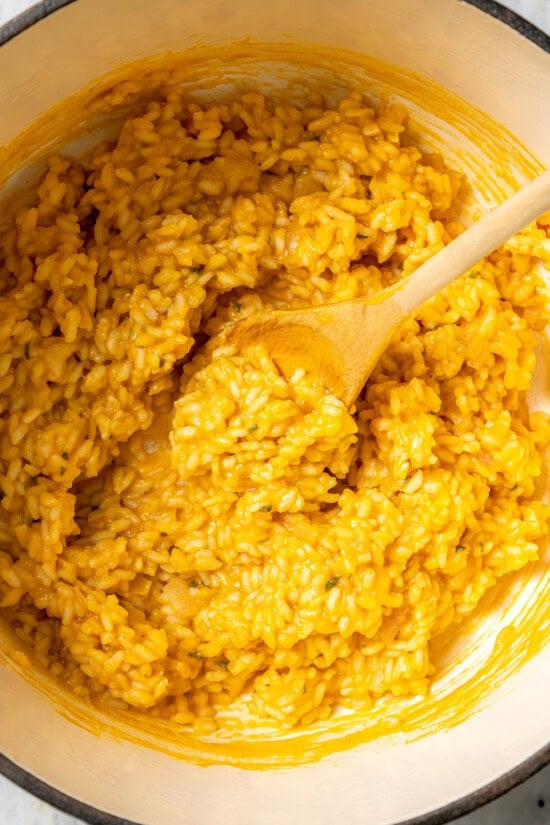 Butternut squash risotto is creamy, delicious and satisfying! It takes a little time, but it’s still easy to make—and absolutely worth it! Creamy butternut squash risotto in Dutch oven with wooden spoon