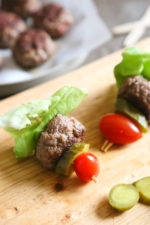 Mini burgers with bacon, layered on a bamboo skewer with lettuce, tomatoes and pickles! Who can resist your favorite foods on a stick – not me! These burger bites make the perfect low-carb appetizer to please everyone from age six to age sixty, just set out some ketchup and mustard for dipping and watch them disappear.