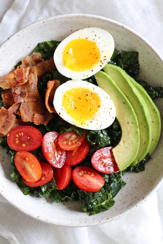 Salad for breakfast? Yes!! This Breakfast BLT Salad can be eaten anytime of the day really, but eggs and bacon served over this simple massaged kale salad with avocado and tomatoes is a delicious, savory, healthy breakfast idea.