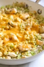 Skillet Cheesy Chicken and Veggie "Rice" made with riced broccoli and cauliflower, sauteed chicken and cheddar cheese. It's so fast and easy to make!