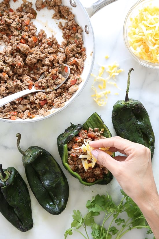 These baked Turkey Enchilada Stuffed Poblanos Rellenos are peppers stuffed with a flavorful ground turkey filling, topped with my homemade enchilada sauce and cheese.