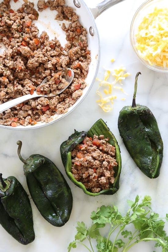 These baked Turkey Enchilada Stuffed Poblanos Rellenos are peppers stuffed with a flavorful ground turkey filling, topped with my homemade enchilada sauce and cheese.