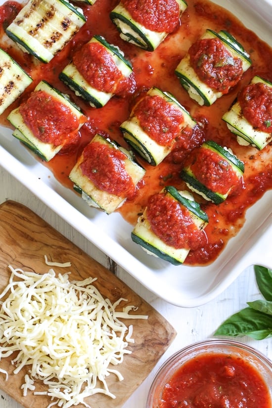 Noodle-less Zucchini Rollatini is low-carb and delicious! Made with strips of grilled zucchini stuffed with a basil-cheese filling, then rolled and topped with marinara, mozzarella and baked in the oven until the cheese is hot and melted.