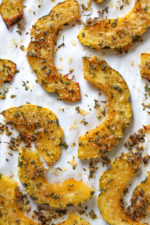 Roasted Delicata squash is delicious topped with a Parmesan-herb crust. The edges come out crisp, golden and delicious. Whether you serve it as a healthy snack or a side dish, this roasted delicata squash recipe is always a winner!
