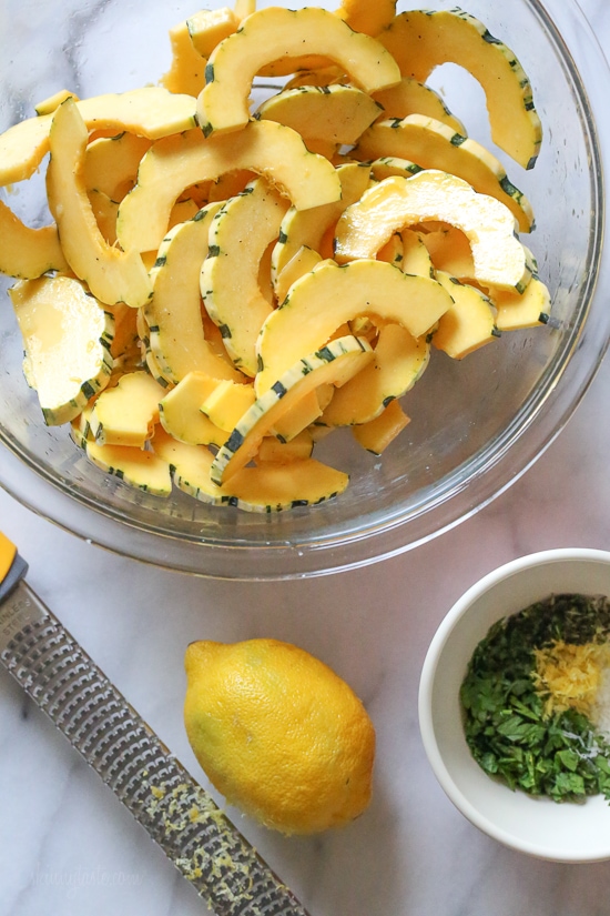 Roasted Delicata squash is delicious topped with a Parmesan-herb crust. The edges come out crisp, golden and delicious. Roasted Delicata squash sliced into half moons before roasting.