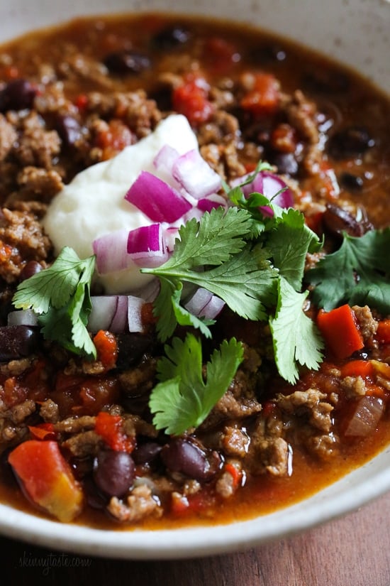 Hearty, filling, and ready in an hour, this is truly the best chili recipe! Made with beans, beef, and a blend of spices. A bowl of easy beef chili topped with onions and cilantro