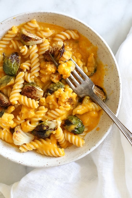 Creamy, Pumpkin Mac and Cheese with Roasted Veggies is comfort food, in a bowl! Made with pumpkin puree, roasted cauliflower and Brussels sprouts.
