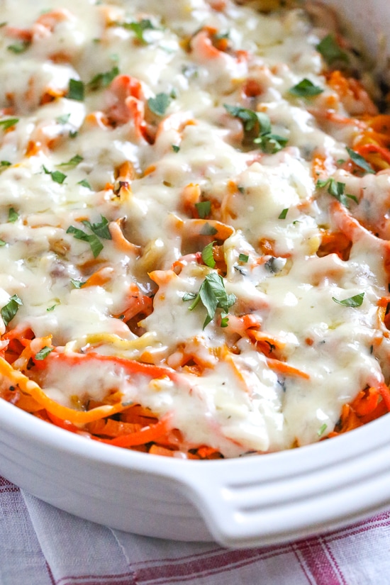 Spiralized Winter Veggie Gratin is the perfect holiday side dish! Made with spiralized vegetable gratin is made with sweet potatoes, butternut squash, carrots, and parsnips and topped with a white sauce and Gruyere cheese.